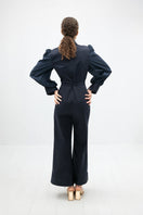 Navy blue Lilianne jumpsuit by ANA + MARIA, featuring a fitted silhouette and stylish neckline, displayed on a hanger.