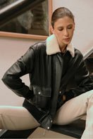 Black ZUT Limber bomber jacket featuring a classic design with a ribbed collar and cuffs, displayed on a hanger.