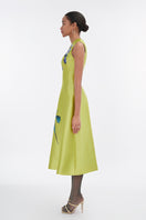 Lime green sleeveless midi dress by Tiny Ink, flowing fabric, round neckline, and midi length, displayed on a hanger.