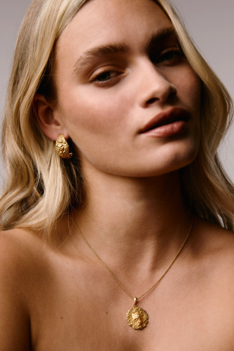 Gold lion hoop earrings by Freya Rose featuring intricate lion head detailing on stylish hoops.