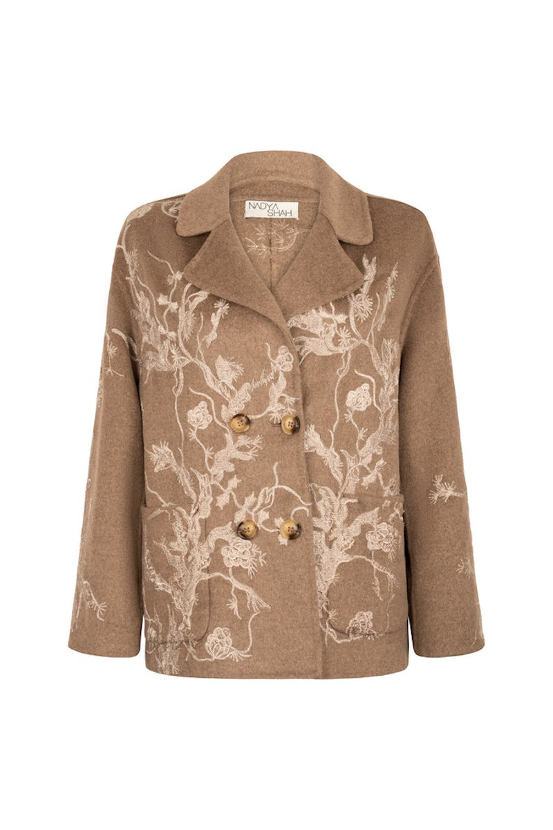 Nadya Shah Louis Biscuit pea coat on mannequin, stylish navy coat with classic double-breasted design and lapel collar.