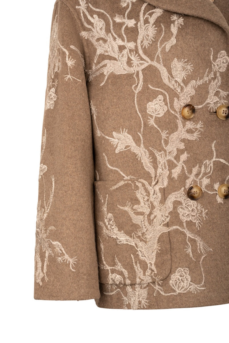 Nadya Shah Louis Biscuit pea coat in beige, tailored with double-breasted buttons and classic collar, displayed on a hanger.