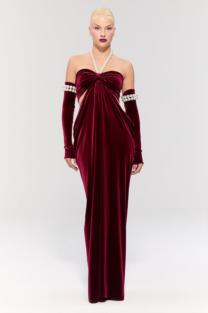 Elegant red gown by Nur Karaata from the Royal Ancestry collection, featuring flowing fabric and intricate design details.
