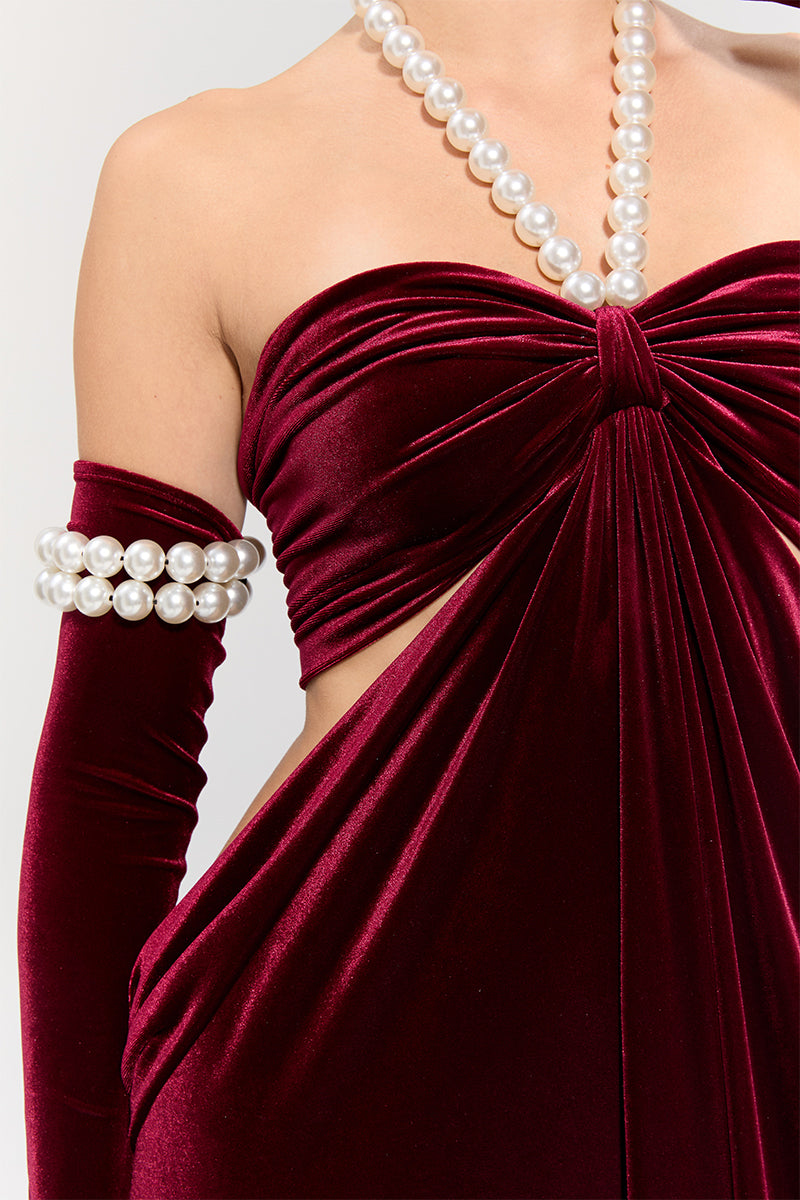 Elegant red gown by Nur Karaata from the Royal Ancestry collection, featuring intricate design and flowing fabric.