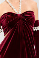Elegant red gown by Nur Karaata from the Royal Ancestry collection, featuring intricate design and flowing fabric.