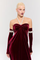 Elegant red gown by Nur Karaata from the Royal Ancestry collection, featuring intricate details and flowing fabric.