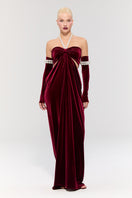 Elegant red gown by Nur Karaata from the Royal Ancestry collection, featuring flowing fabric and intricate design details.