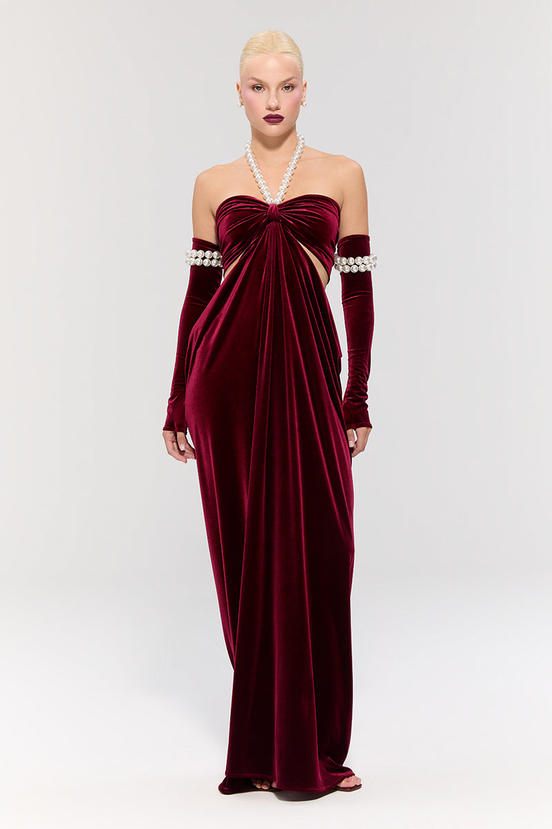 Elegant red gown by Nur Karaata from the Royal Ancestry collection, featuring flowing fabric and intricate design details.