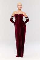 Elegant red gown from Nur Karaata's Royal Ancestry collection, featuring intricate detailing and flowing fabric.