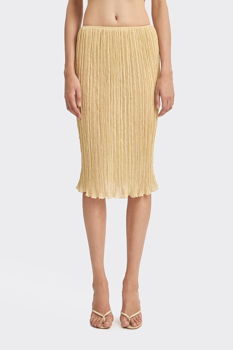 Yellow Lotus pleated knee-length midi skirt by Stolen Stores, showcasing its flowy fabric and flattering pleats.