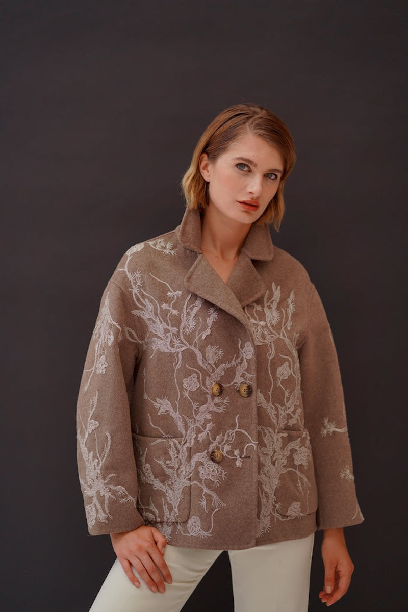 Nadya Shah Louis Biscuit peacoat, stylish coat with classic double-breasted design in beige, displayed on a hanger.