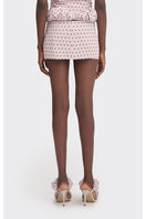 Purple Kapi polka dot mini skirt with a low waist, made by Stolen Stores, shown on a model with a casual outfit.