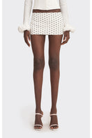 Off-white polka dot low waist mini skirt by Stolen Stores, displayed on a model in a fashion photoshoot.
