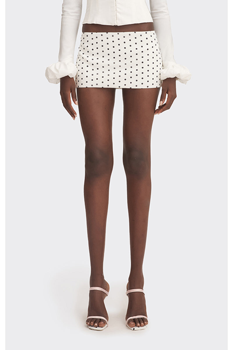 Off-white polka dot low waist mini skirt by Stolen Stores, displayed on a model in a fashion photoshoot.