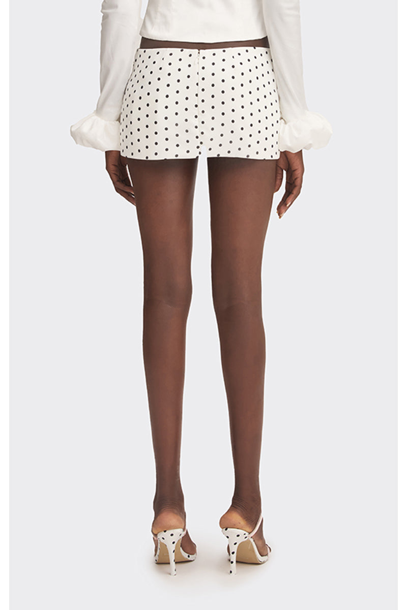 Off-white low waist mini skirt with black polka dots from Stolen Stores, shown on a model against a neutral background.