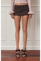 Dark brown polka dot mini skirt with a low waist style from Stolen Stores, shown on a model.