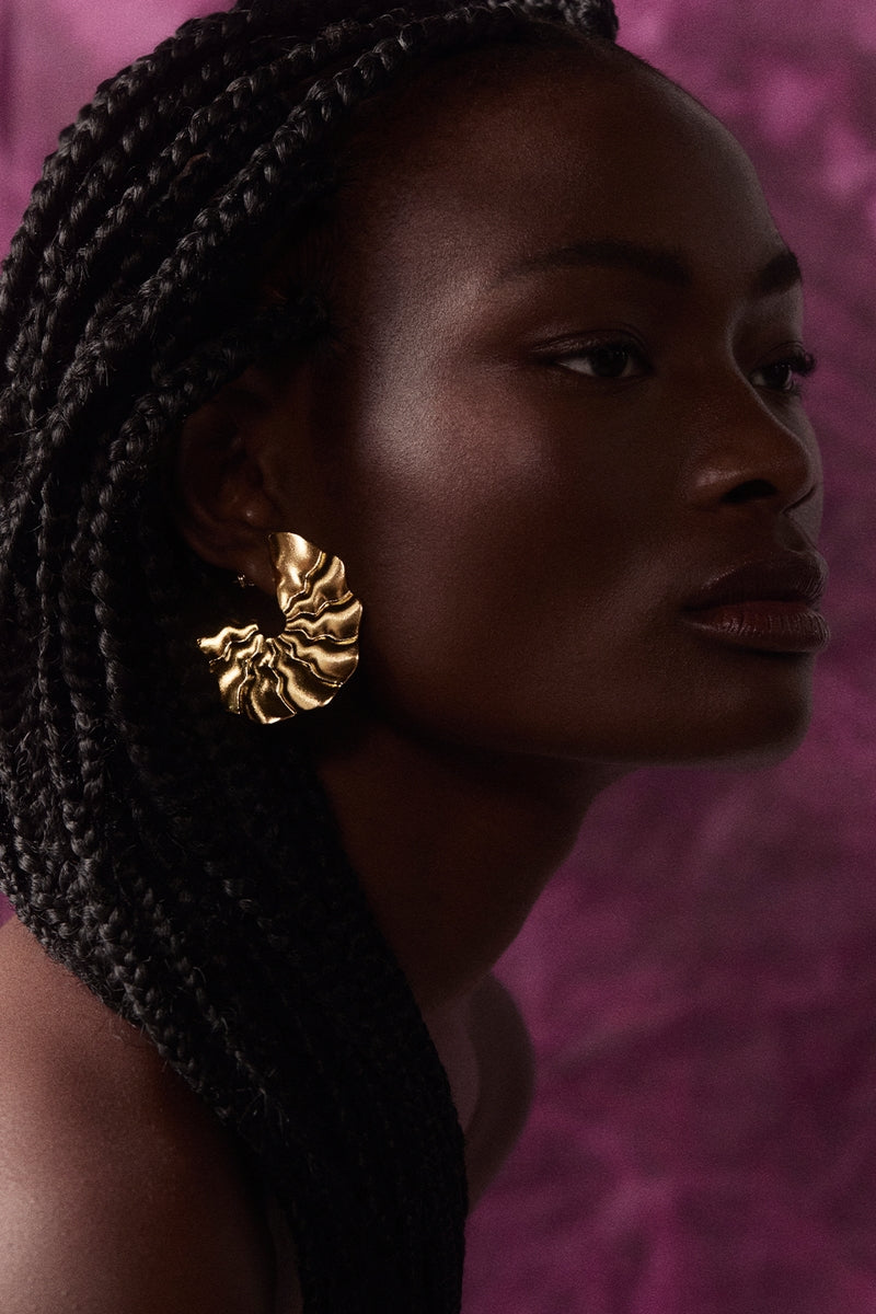 Gold wavy hoop earrings by Maria Frering featuring a stylish, textured design perfect for everyday wear.