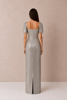 Silver Lujain sequin gown by Nihan Peker featuring intricate sequin details and elegant flowing fabric.