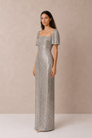 Silver Lujain sequin gown by Nihan Peker featuring intricate sequin details and elegant flowing fabric.