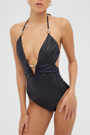 Shiny black Luna one-piece swimsuit by Maliluha displayed on a model, showcasing sleek design and fit.