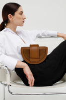 ISIDORA MALVA Luna clutch in toffee color, featuring a sleek design and shoulder strap, perfect for stylish occasions.