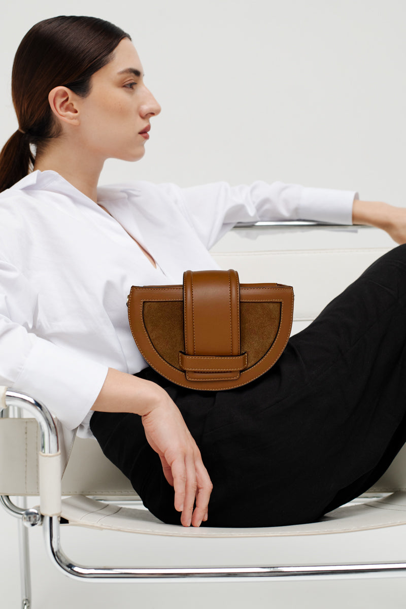 ISIDORA MALVA Luna clutch in toffee color, featuring a sleek design and shoulder strap, perfect for stylish occasions.
