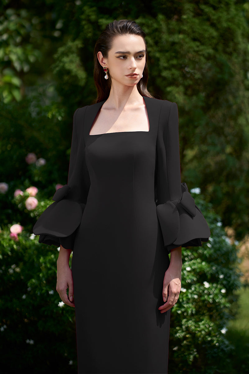 Black column gown with trapeze neckline and rose-draped three-quarter sleeves, designed by I.H.F.
