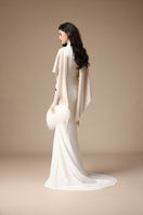 Elegant Jenny K Tran Maraidress gown in off-white and beige with flowing fabric and intricate design details.
