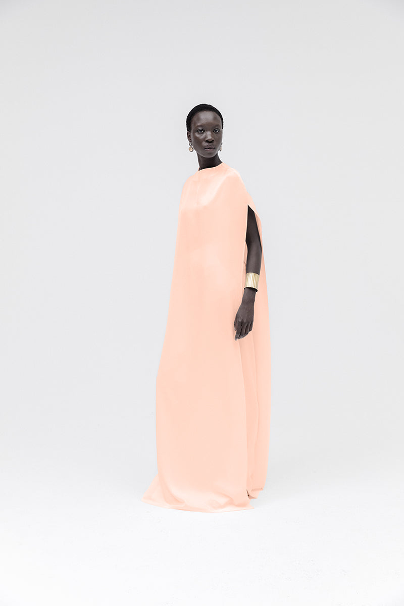 Studio NK marble cape top in peach with a flowing, textured fabric, featuring a stylish draped design and elegant appearance.