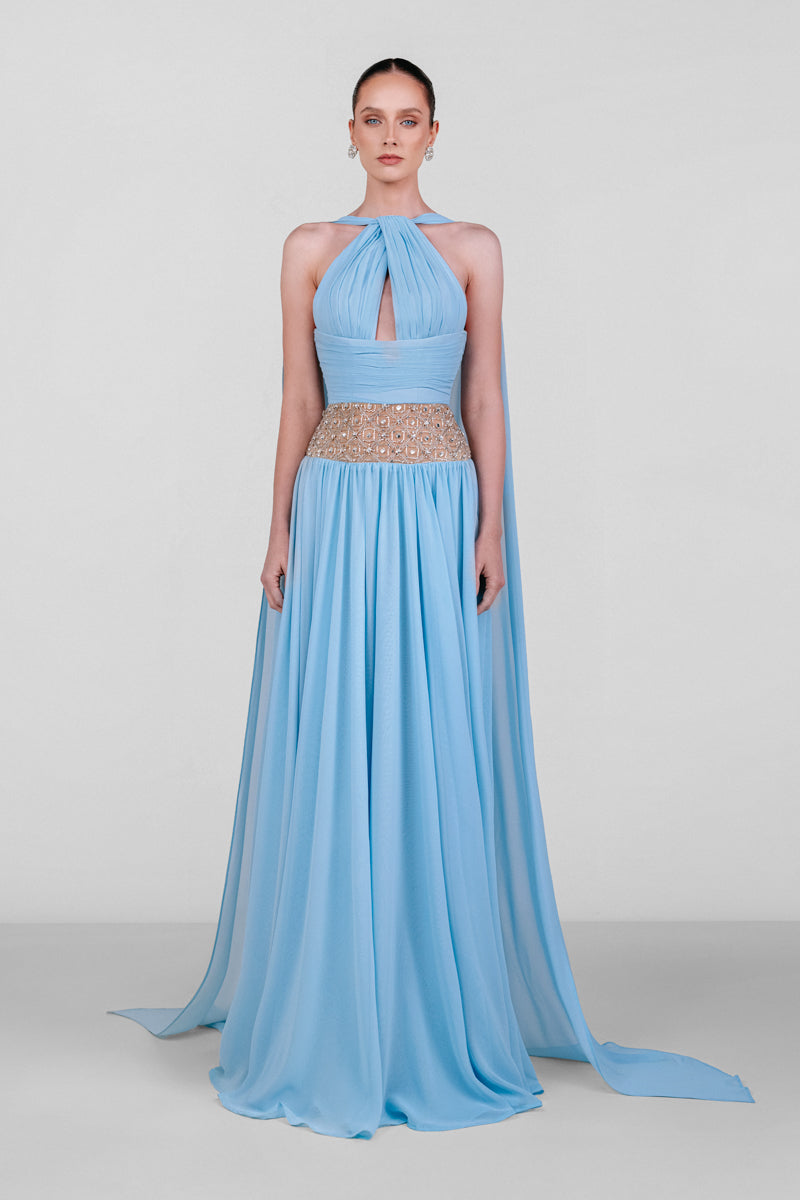 Blue embellished chiffon gown by Monika Dimova, featuring intricate beadwork and flowing fabric, elegant evening wear.
