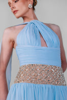 Blue embellished chiffon gown by Monika Dimova featuring intricate beadwork and flowing fabric for elegant evening wear.