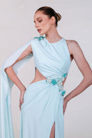 Blue embellished cape gown by Monika Dimova featuring intricate embroidery and flowing fabric, elegant evening dress.