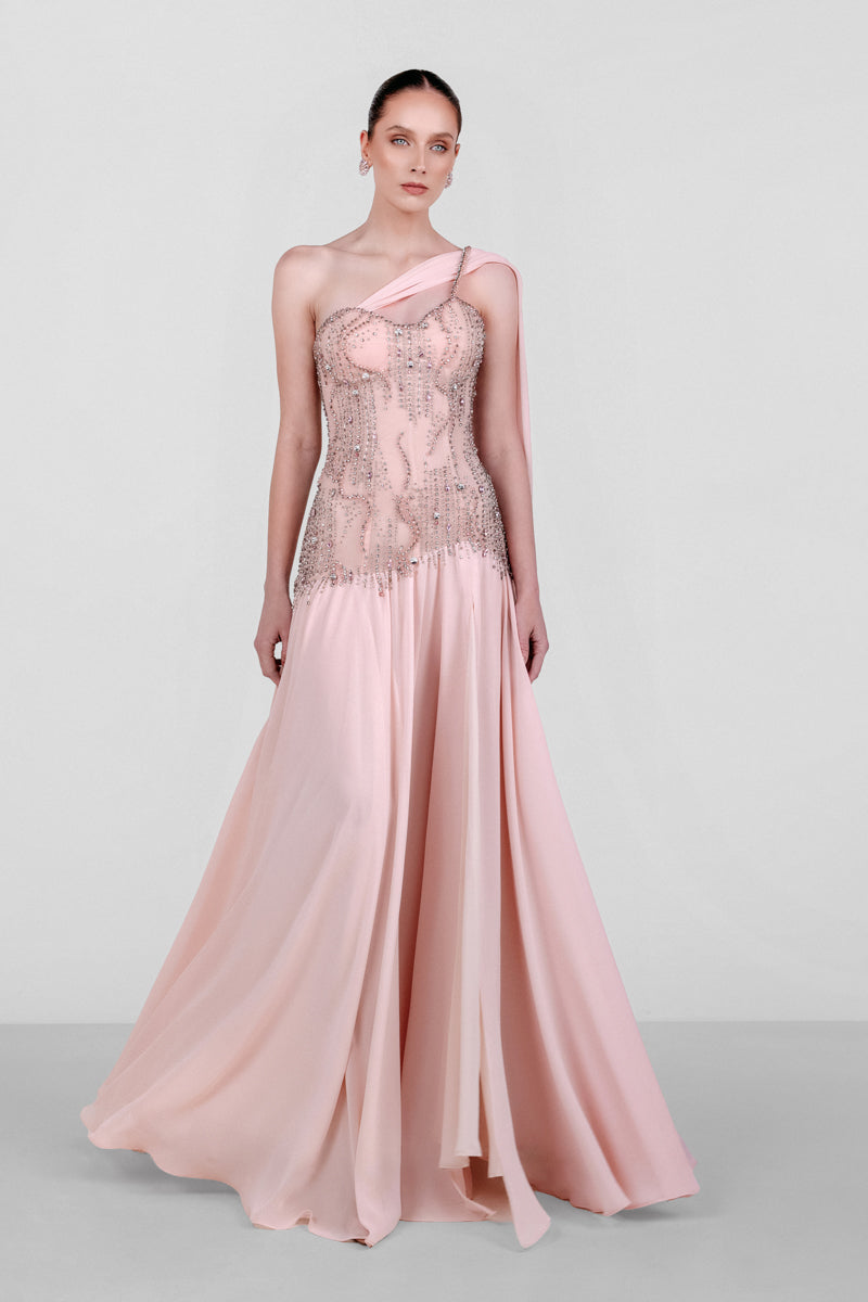 Elegant blush embellished cape gown by Monika Dimova, featuring intricate details and flowing fabric for a sophisticated look.