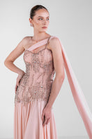 Elegant blush embellished cape gown by Monika Dimova featuring intricate embroidery and flowing fabric.