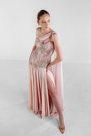 Elegant blush embellished cape gown by Monika Dimova, featuring intricate detailing and flowing fabric.