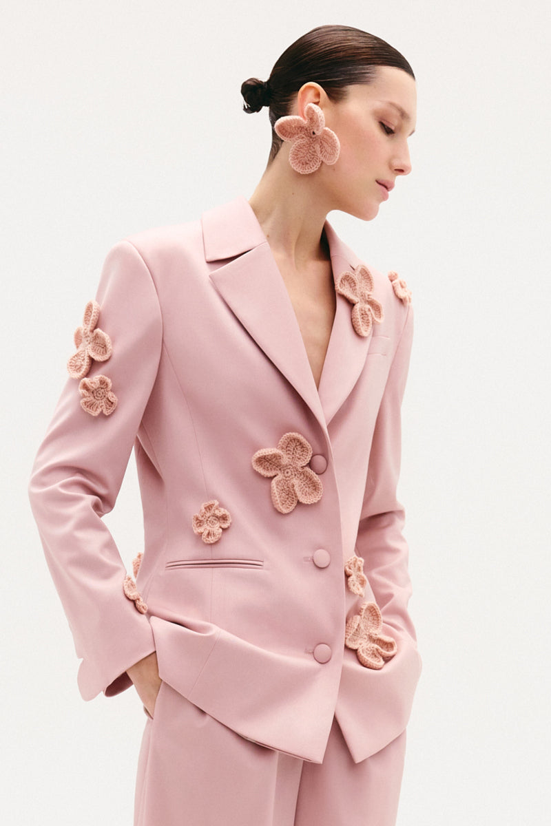 Malva Florea classic hourglass jacket with crochet floral appliqués in powder, showcasing elegant design and intricate detailing.