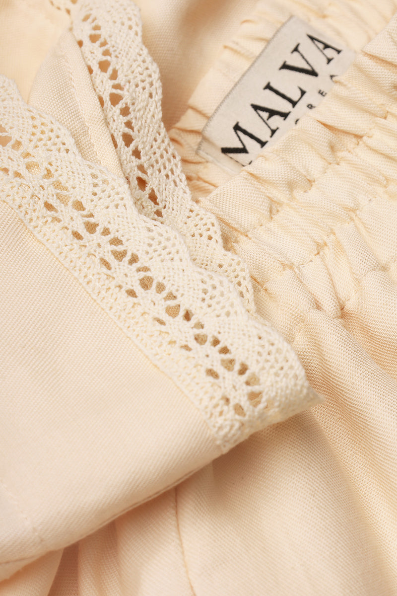 Close-up of Malva Florea matching high-waisted shorts pants with floral pattern and tailored fit, showcasing stylish design details.