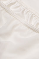 White high-waisted column midi skirt by Malva Florea, close-up showing smooth fabric and tailored fit.