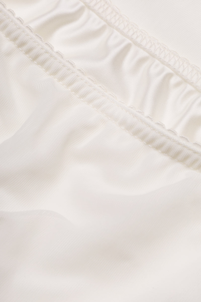 White high-waisted column midi skirt by Malva Florea, close-up showing smooth fabric and tailored fit.