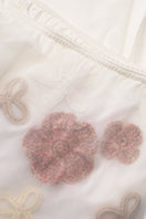 White high-waisted embellished pencil midi skirt by Malva Florea with floral appliques and intricate detailing.