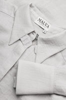Relaxed-fit gray blouse by Malva Florea, shown on a hanger with soft fabric and casual, stylish design.
