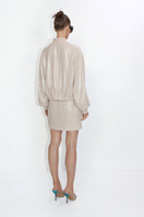 Beige mini skirt with shiny sequins from MALVA FLOREA, featuring a fitted design and stylish detail.