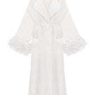 Ivory cape-style trench coat by Malva Florea, shown with wide lapels and belt, displayed on a mannequin.
