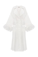 Ivory cape-style trench coat by Malva Florea, shown with wide lapels and belt, displayed on a mannequin.