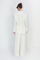 Malva Florea classic tailored ivory pants with a sleek fit, shown on a model in a stylish, professional setting.