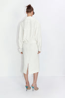 Ivory high-rise midi skirt by Malva Florea, featuring a flowing design and elegant length, shown on a model.
