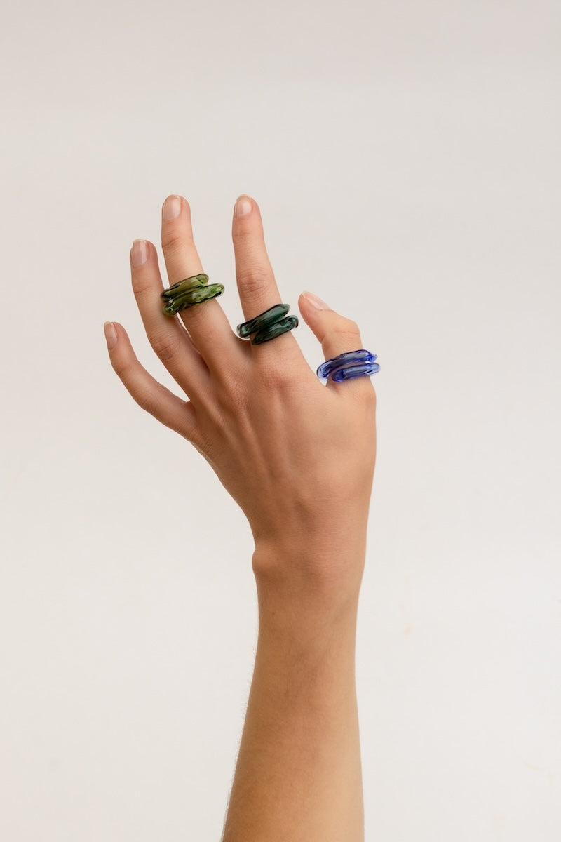 Set of three SALVÁREA rings featuring turquoise, green, and ocean blue colors, displayed stacked on a white background.