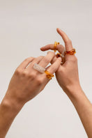 Set of SALVÁREA pink, amber, and white Remolino rings featuring colorful, swirling designs on silver bands.