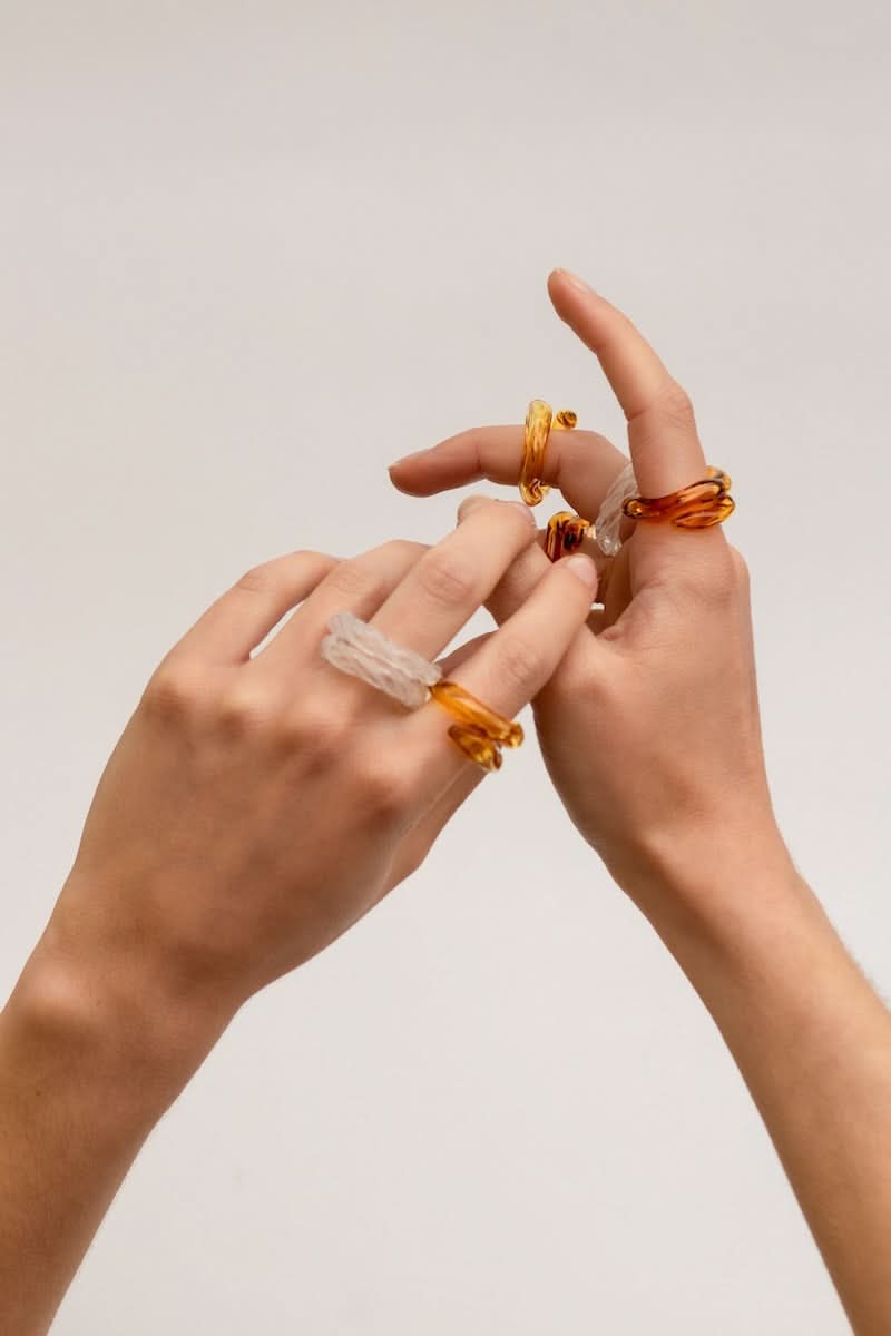 Set of SALVÁREA pink, amber, and white Remolino rings featuring colorful, swirling designs on silver bands.
