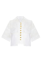 White LINA shirt by LAURA ESCOBAR featuring a classic fit, button-down front, and soft fabric, displayed on a hanger.